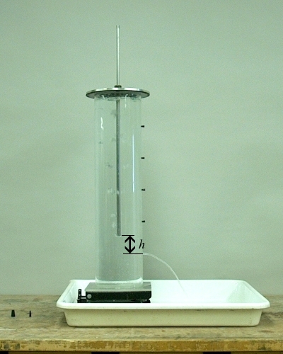 Mariotte bottle, with the bottom of the tube raised to height h above the open lowest hole. A stream flows out at constant pressure as air flows in from the tube.